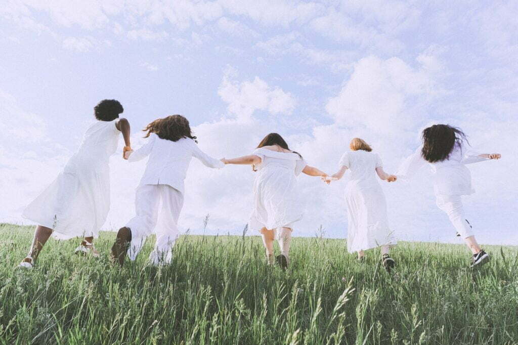 five women are enjoying nature together.  They are enjoying the natural connection without the need for things and consumerism.